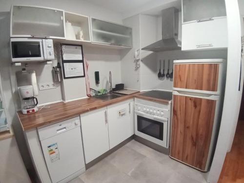 a small kitchen with white appliances and wooden counters at MERINDADES AMAZUL MILANO - Piso turístico - Medina de Pomar in Medina de Pomar