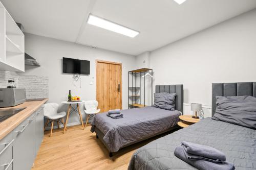 a bedroom with a bed and a kitchen with a table at Central Platinum Apartments 5 Studio z aneksem kuchennym i tarasem in Rybnik