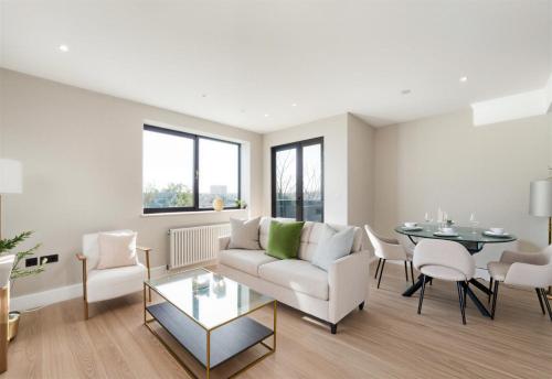 a living room with a couch and a table and chairs at The Wimbledon Collection 2 Bed Apartments in London