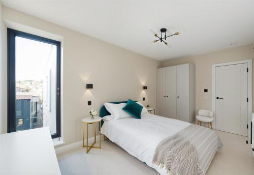 a white bedroom with a bed and a large window at The Wimbledon Collection 2 Bed Apartments in London