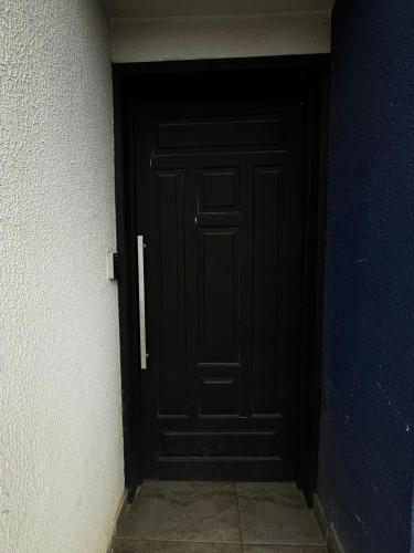 a black door in a corner of a room at Apartamento no Centro de Sengés Quarto 01 in Sengés