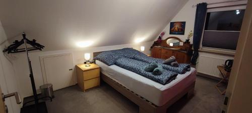 ein Schlafzimmer mit einem Bett, einer Kommode und einem Fenster in der Unterkunft Gemütliches Gästezimmer in Flensburg-Weiche in Flensburg