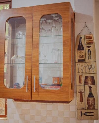 un mobile in legno con ante in vetro in una cucina di Makinihomestay ad Arusha