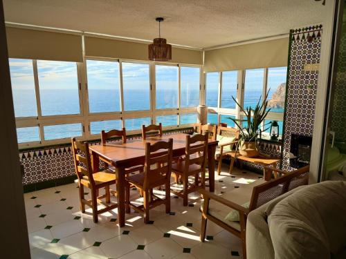 a dining room with a table and chairs and the ocean at El Barco in Almería