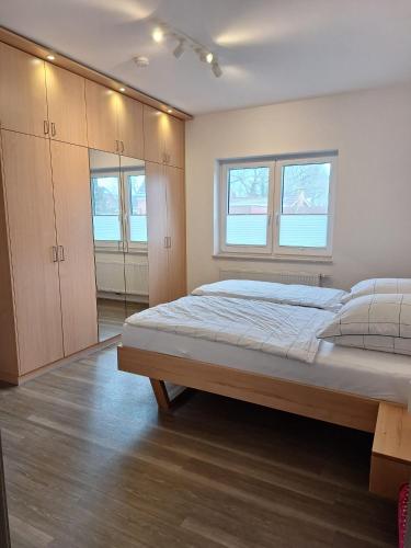 a bedroom with a bed and some windows at Huus 8 in Westoverledingen