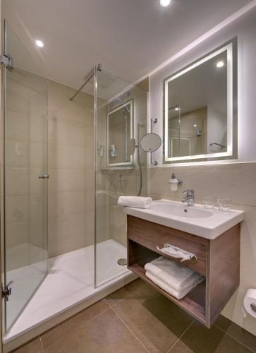 a bathroom with a sink and a shower at GenoHotel Baunatal in Baunatal