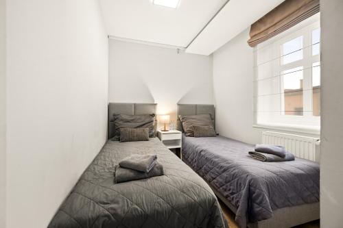 two beds in a small room with a window at Central Platinum Apartments 14 in Rybnik