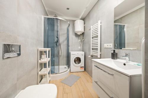 a bathroom with a shower sink and a washing machine at Central Platinum Apartments 14 in Rybnik
