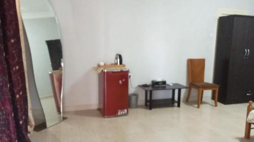 a room with a red refrigerator and a table at House Al Ain - 5 in Al Ain