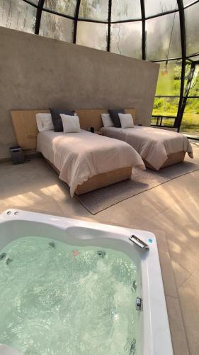 a room with two beds and a bath tub at Mineral Glamping Experience in Mineral del Chico