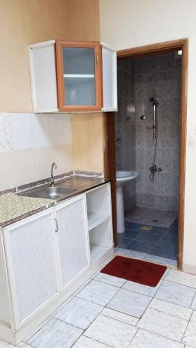 a kitchen with a sink and a shower in a bathroom at House Al Ain - 5 in Al Ain