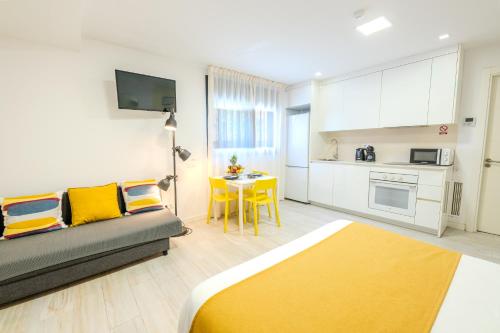 a living room with a couch and a kitchen at Castell Beach Aparthotel in Castelldefels