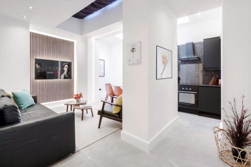 a living room with a couch and a kitchen at LONDONERS - Marylebone Serviced Apartments in London