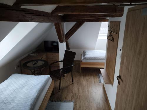 a attic bedroom with a bed and a desk and a table at Penzion U Koruny in Ústí nad Labem