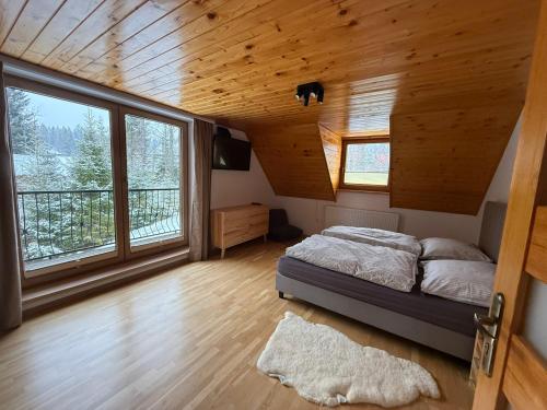 a bedroom with a bed and a large window at Chata Diana in Oravice