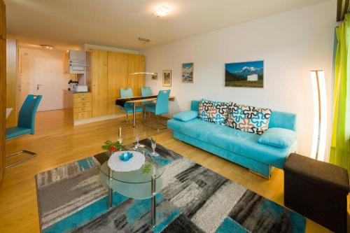 a living room with a blue couch and a table at Studio Türkis in Grächen