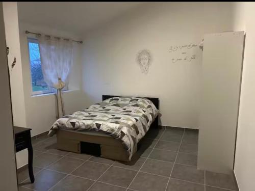 a bedroom with a bed in a white room at Chez aurelie in Agnin