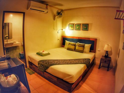 a bedroom with a large bed and a bathroom at Lanta at Home - SHA Extra Plus in Ko Lanta