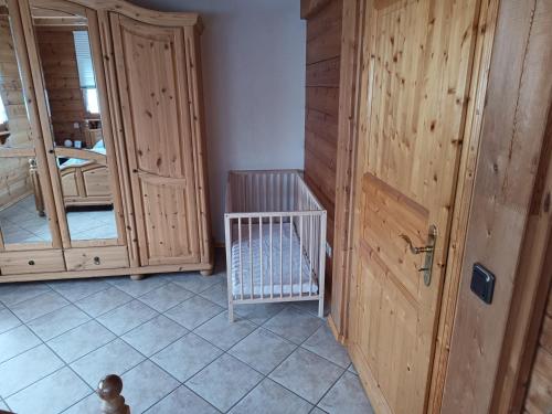 a room with a wooden door and a crib at Ferienwohnung Bermbach in Weilburg