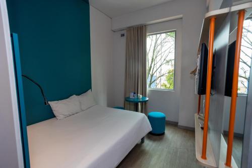 a small room with a bed and a window at ibis budget Medellín Itagüí Metro in Medellín