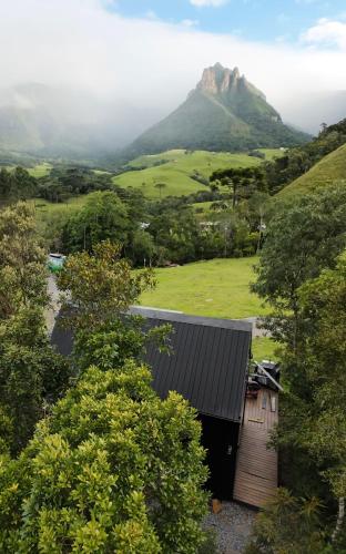 a wooden cabin with a mountain in the background at Cabana do Céu - Soldados Sebold in Alfredo Wagner