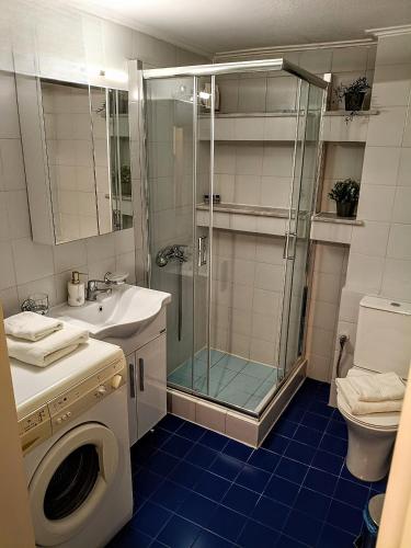 a bathroom with a shower and a washing machine at Vallia Suites - Double suite B1 in Nafpaktos