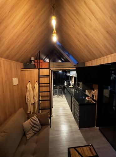 a living room with a couch and a kitchen at Cabana do Céu - Soldados Sebold in Alfredo Wagner