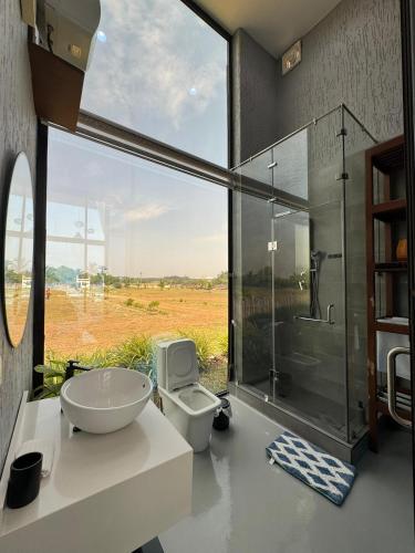 un bagno con wc e doccia in vetro di The Paralia a Brunibuma