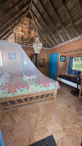 a bedroom with a large bed with a mosquito net at Tikehau Paradise in Tikehau Airport