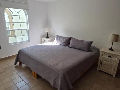 a bedroom with a bed and a window at Casa del Árbol Querétaro in Querétaro