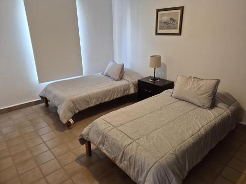 a room with two beds and a lamp on a table at Casa del Árbol Querétaro in Querétaro