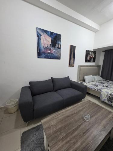 a living room with a couch and a bed at Apartment condo in Ajman in Ajman 
