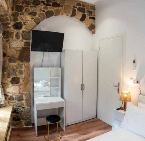 a bedroom with a white desk and a stone wall at Kos View City , Luxury Old Town in Kos