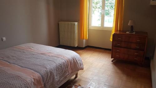 a bedroom with a bed and a dresser and a window at La choletaise spacieuse et proche des axes routiers in Cholet