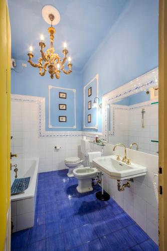 a bathroom with two toilets and a sink and a chandelier at Casa Esvael - Historic Rooms in Verona City Center in Verona