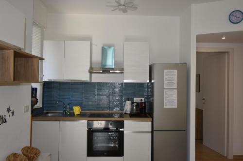 a kitchen with white cabinets and a stainless steel refrigerator at Casa Lorica in Pieve Ligure