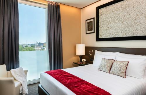 a hotel room with a bed and a large window at Leonardo Royal Hotel Venice Mestre in Mestre