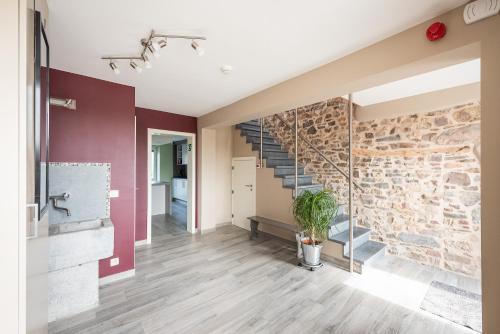a living room with a stone wall and stairs at Mossefat in Sprimont