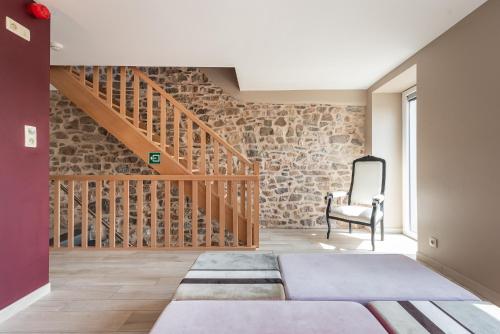 a room with a bed and a wooden staircase at Mossefat in Sprimont