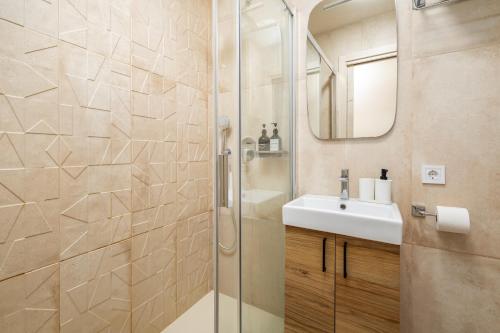a bathroom with a shower and a sink and a mirror at Beachfront Design LUX Studio Apartment in Estepona