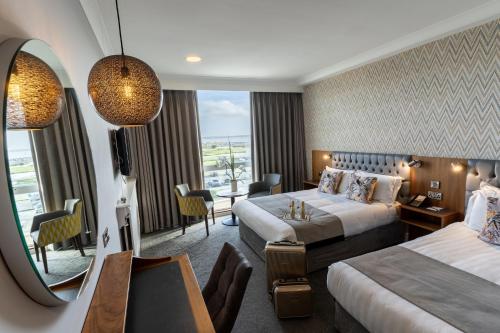 a hotel room with two beds and a mirror at Majestic Hotel in Tramore
