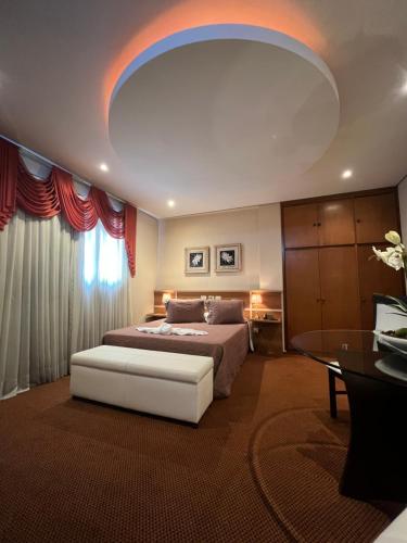 a large bedroom with a bed and a table at Skalla Hotel Nova Odessa in Nova Odessa