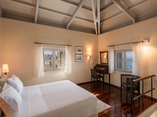 a bedroom with a bed and a desk and windows at Villa Andromeda in Chania