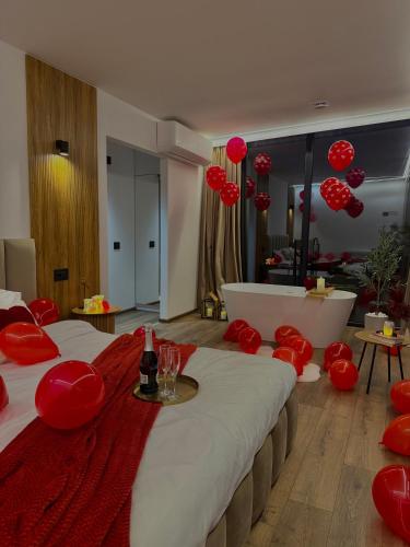 a room with two beds with red pillows and a tub at Nest House in Dubova