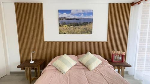 a bed with a pink comforter in a bedroom at Cómodo Apto Lago Sochagota in Paipa