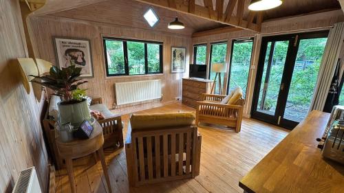 a large living room with wooden floors and windows at Duxford Lodge, Cholsey in Cholsey