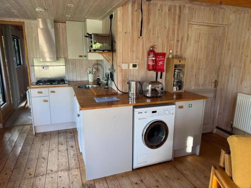 a kitchen with a washer and a washing machine at Duxford Lodge, Cholsey in Cholsey