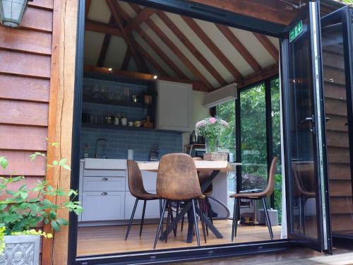 a kitchen with a table and chairs on a deck at Pool House at Mill Cottage in Goring