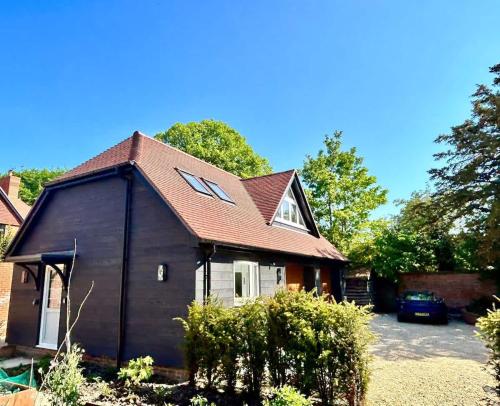 a small house with a gambrel roof at Goring River Retreat with Gym and Wellness Area in Goring