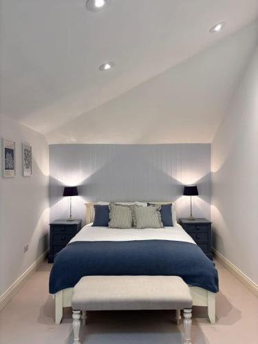 a bedroom with a large bed and two lamps at The Baydon House Luxury Studio in Marlborough
